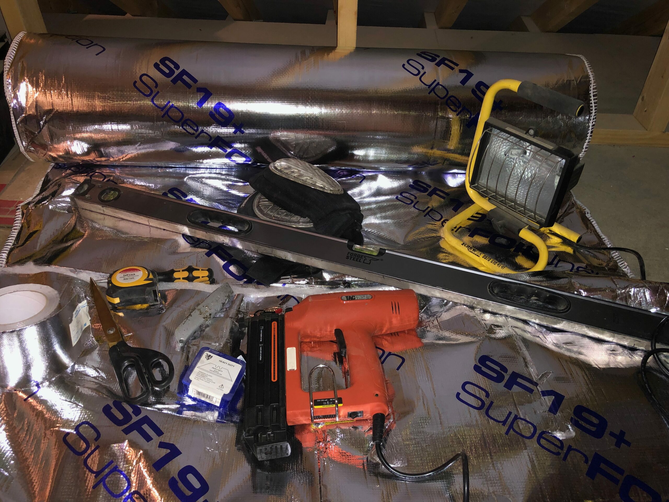 equipment to help install multifoil loft insulation: staplegun, light, spirit level, foil tape, scissors, stanley knife, tape measure, knee pagds