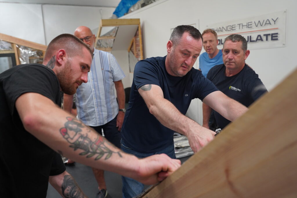 A team of SuperFOIL Approved installers demonstrating their ability to securely install SuperFOIL against timber rafters, while observed by our expert instructors.